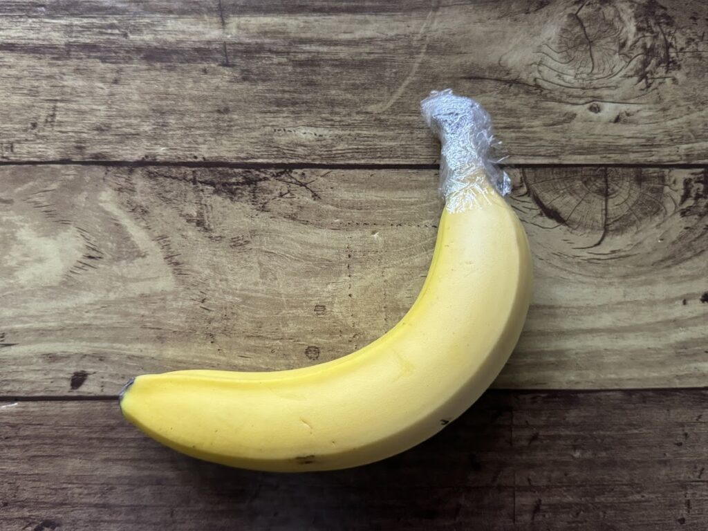 バナナの根元をラップで包む